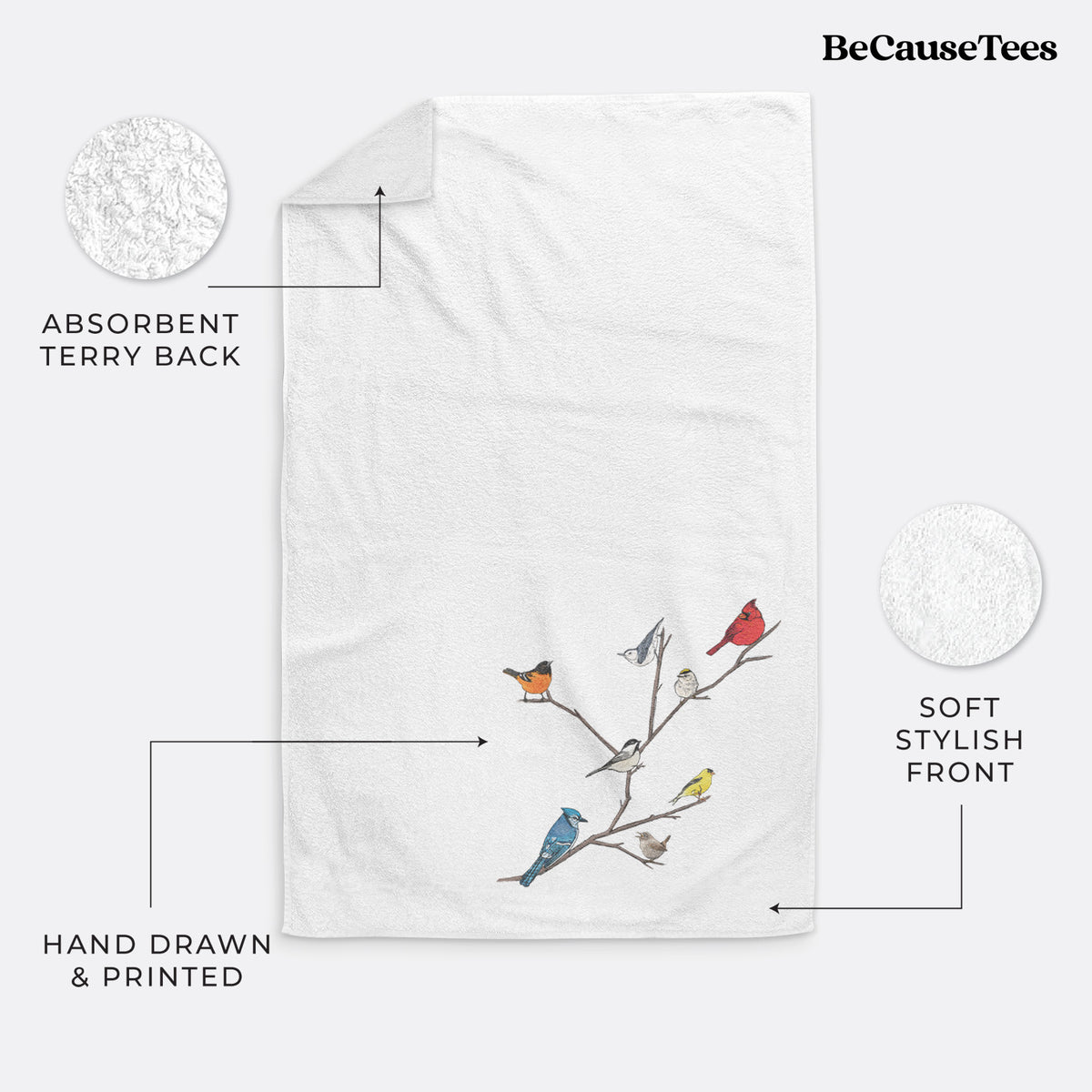 White hand towel printed with a full-color illustration of backyard birds, including a cardinal, blue jay, goldfinch and robin, perched on bare branches.