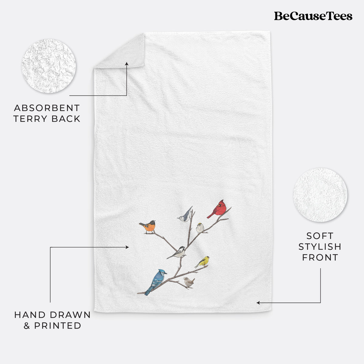 White hand towel printed with a full-color illustration of backyard birds, including a cardinal, blue jay, goldfinch and robin, perched on bare branches.