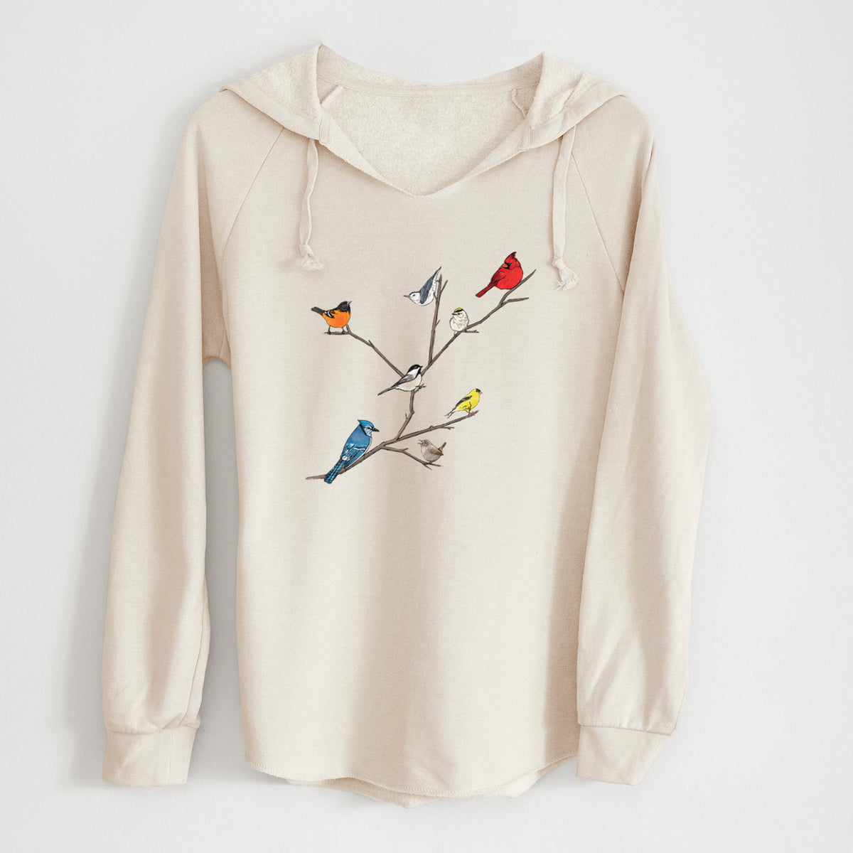 Bone cream women's Cali Wave hooded sweatshirt laid flat, printed with a full-color illustration of backyard birds, including a cardinal, blue jay, goldfinch and robin, perched on bare branches.