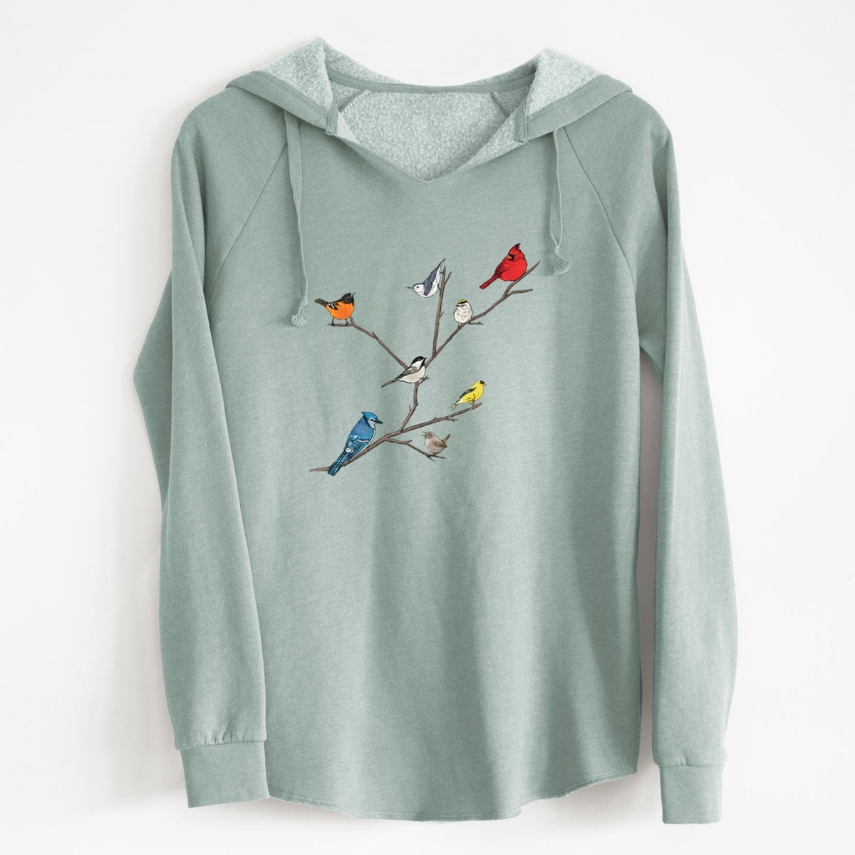 Sage green women's Cali Wave hooded sweatshirt laid flat, printed with a full-color illustration of backyard birds, including a cardinal, blue jay, goldfinch and robin, perched on bare branches.