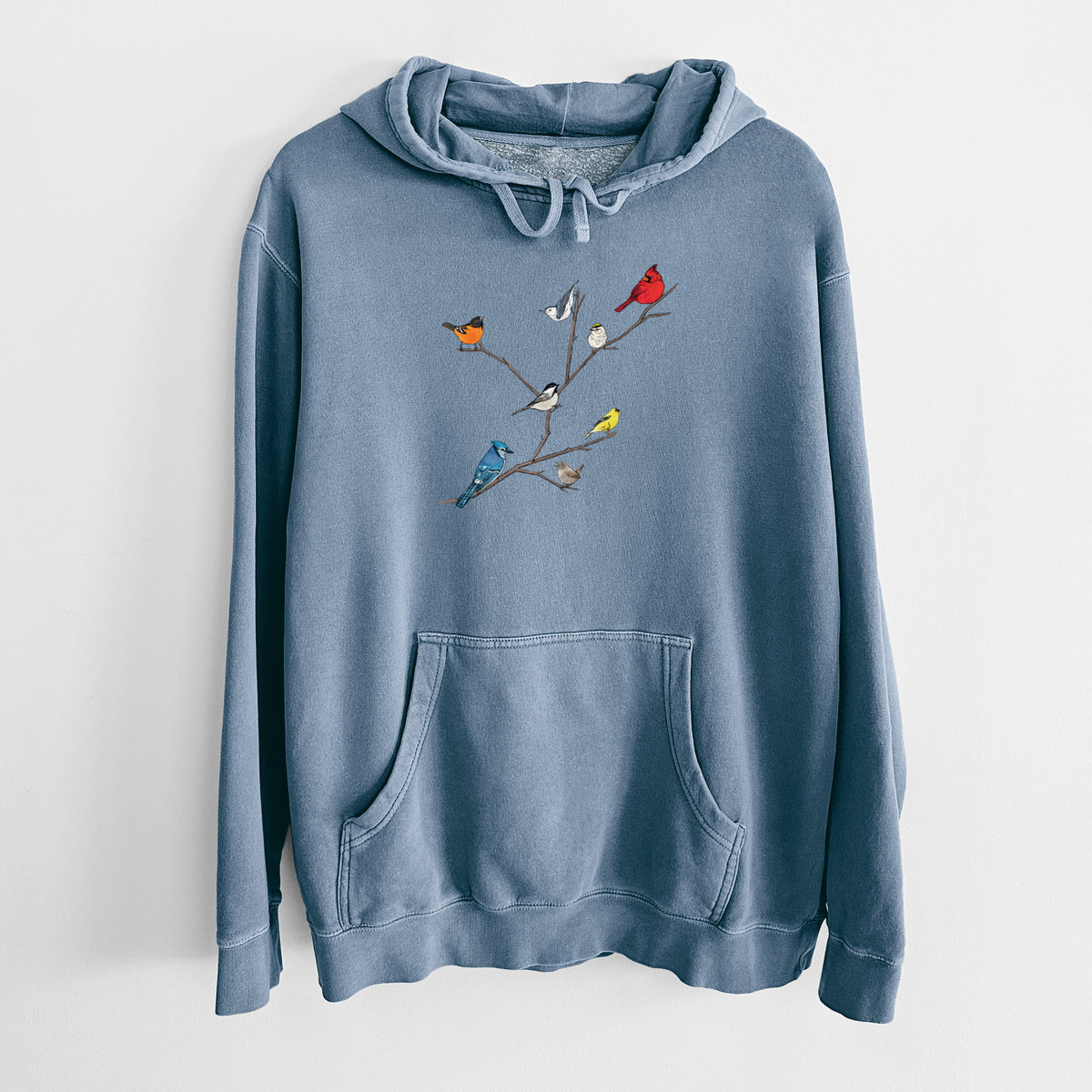 Slate blue pigment dyed hoodie laid flat, printed with a full-color illustration of backyard birds, including a cardinal, blue jay, goldfinch and robin, perched on bare branches.