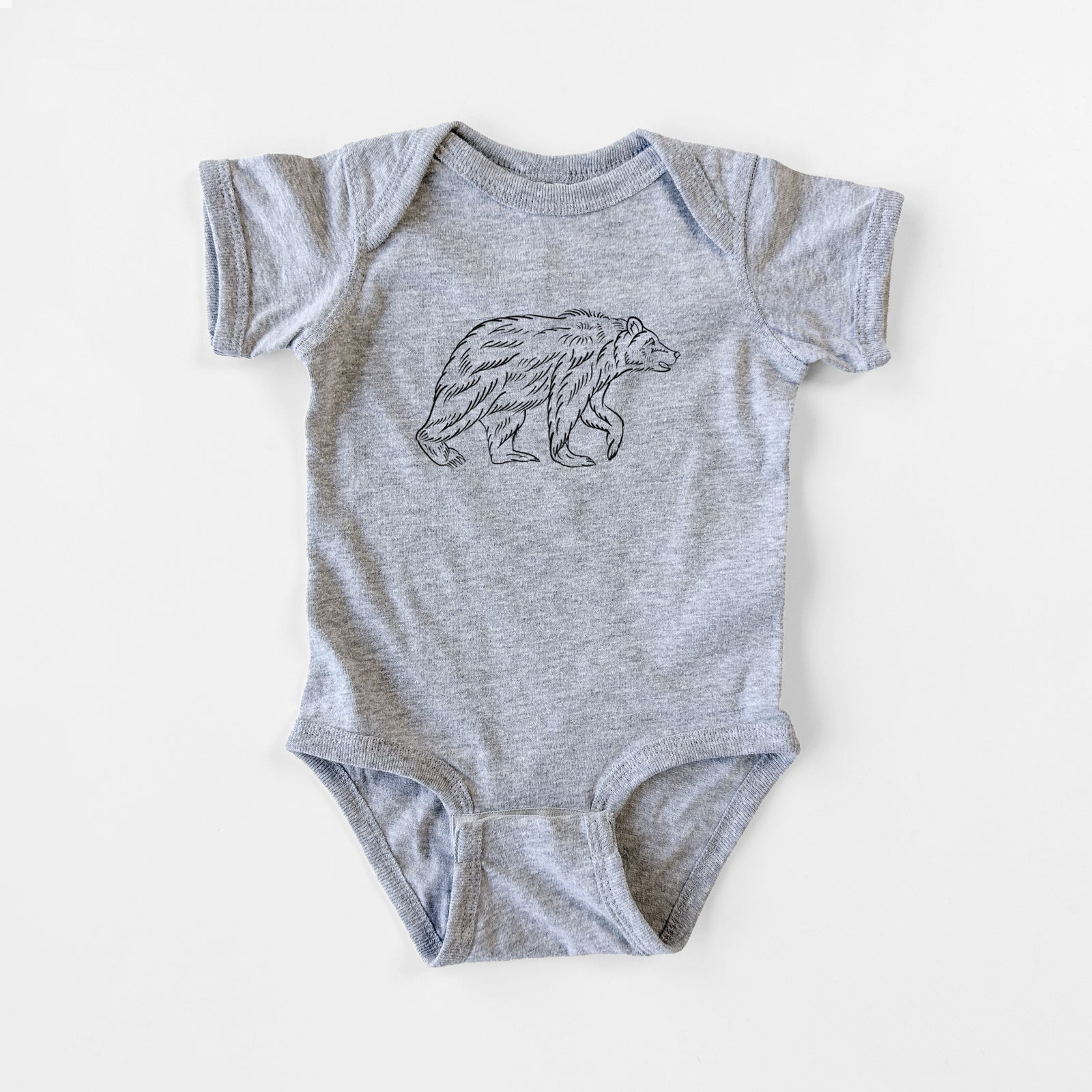 Grey baby bodysuit laid flat, printed with a black ink illustration of a brown bear walking.