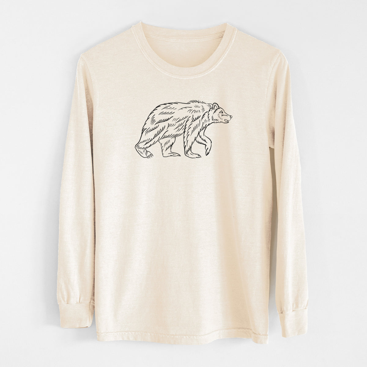 Ivory Comfort Colors long sleeve shirt laid flat, printed with a black ink illustration of a brown bear walking.