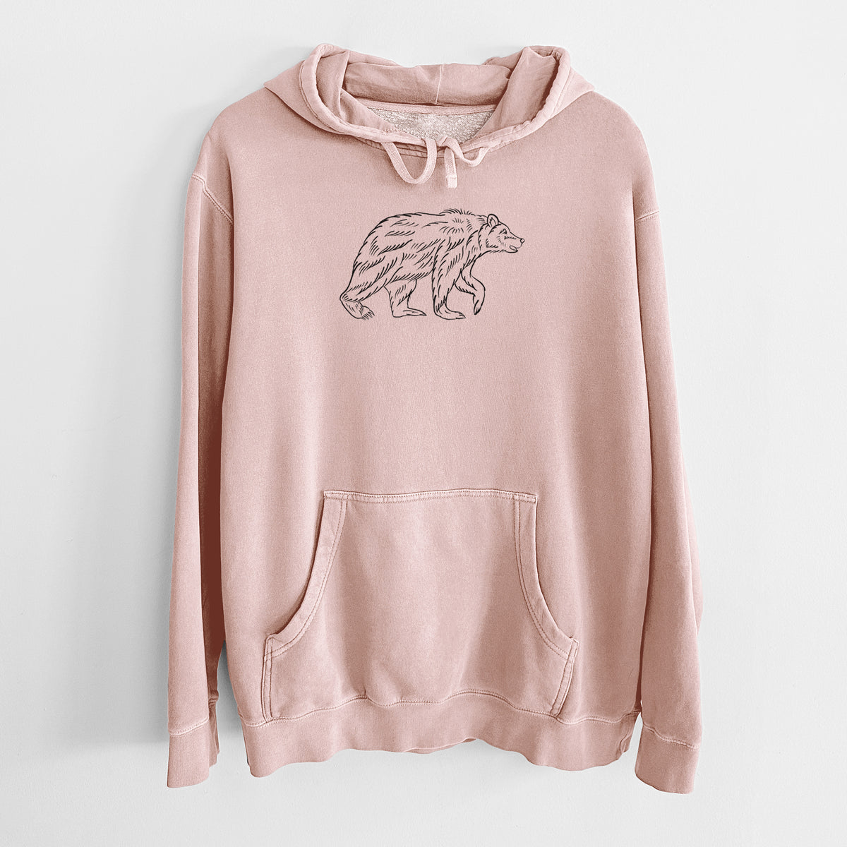 Dusty pink pigment dyed hoodie laid flat, printed with a black ink illustration of a brown bear walking.