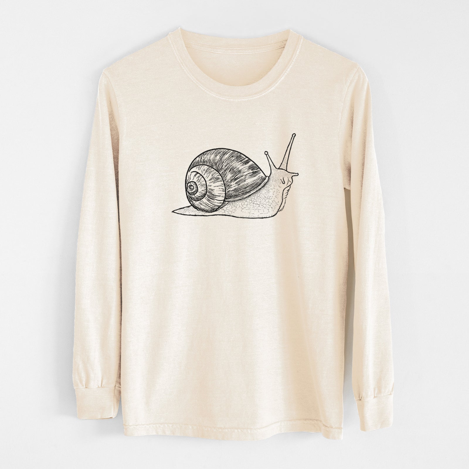 Ivory Comfort Colors long sleeve shirt laid flat, printed with a detailed black ink illustration of a brown garden snail with its spiral shell.