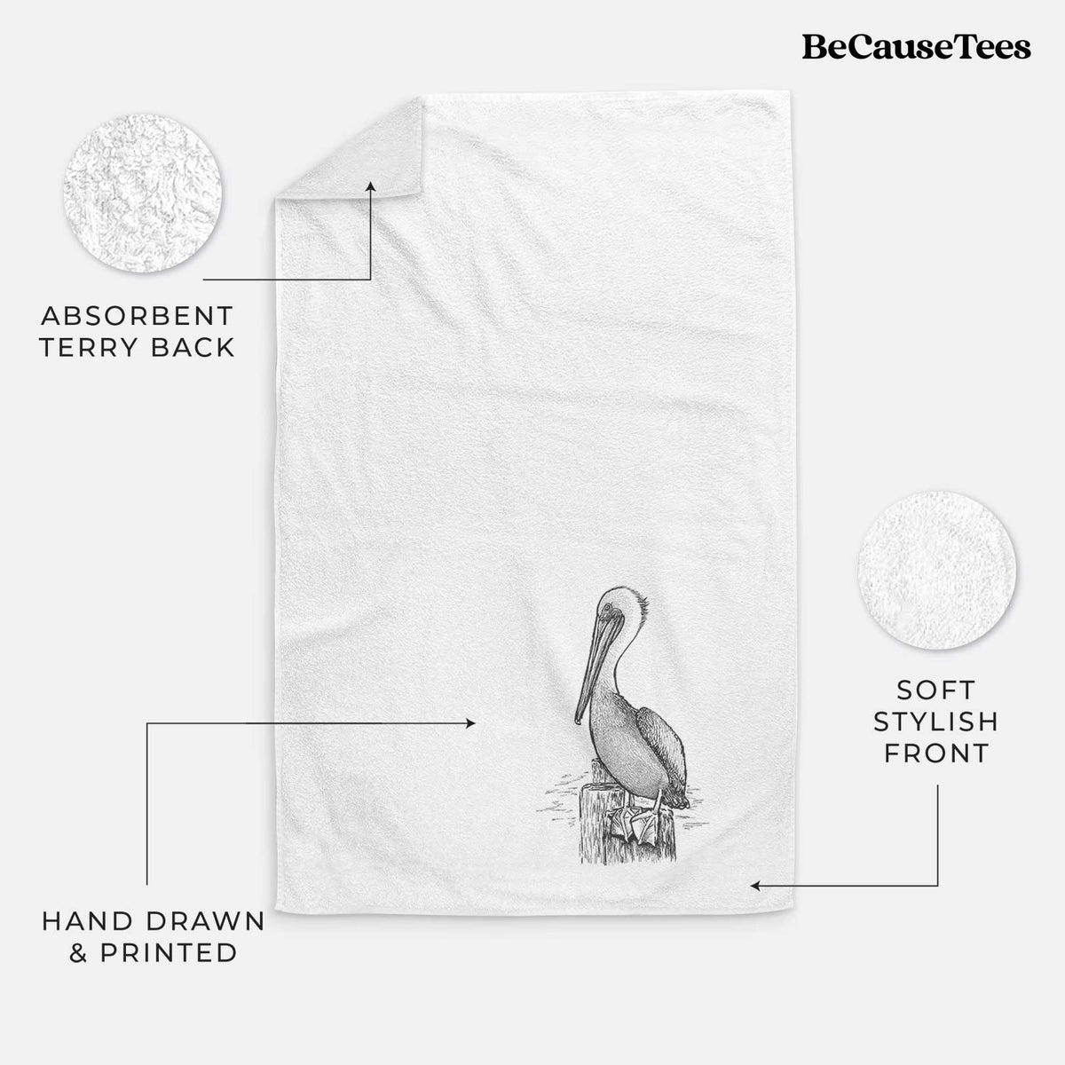 White hand towel printed with a detailed black ink illustration of a brown pelican perched on a wooden piling.
