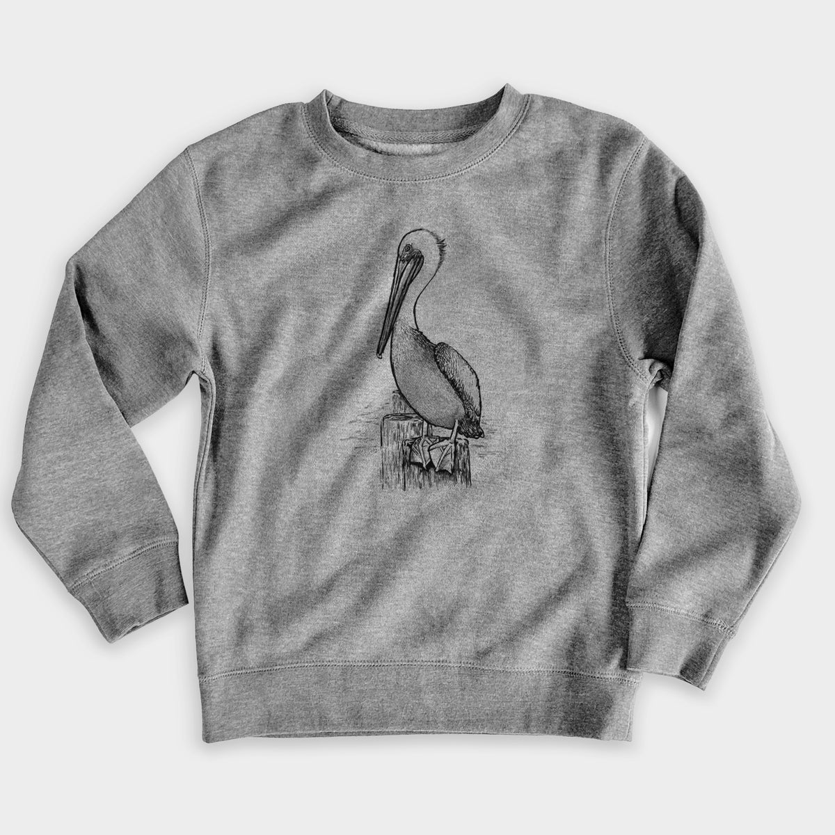 Nickel grey youth crewneck sweatshirt laid flat, printed with a detailed black ink illustration of a brown pelican perched on a wooden piling.
