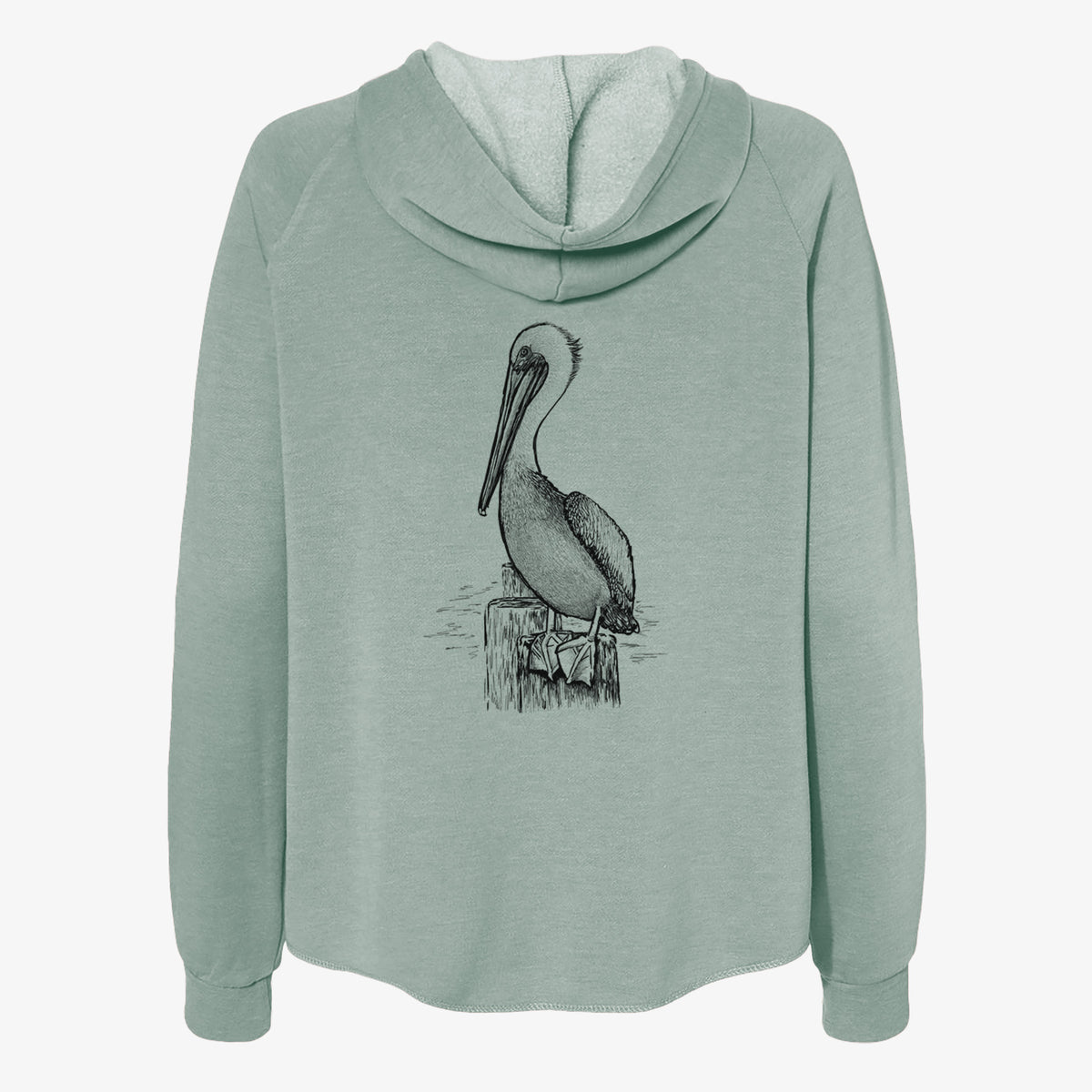 Sage green women's Cali Wave zip-up sweatshirt laid flat, printed with a detailed black ink illustration of a brown pelican perched on a wooden piling.