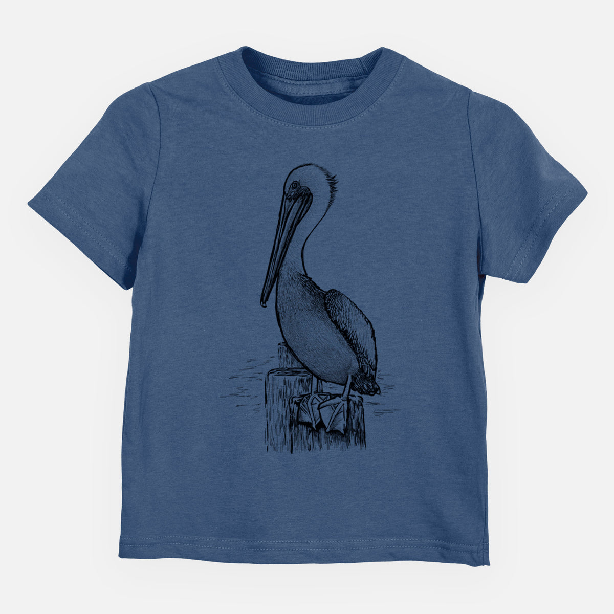 Indigo blue toddler t-shirt laid flat, printed with a detailed black ink illustration of a brown pelican perched on a wooden piling.