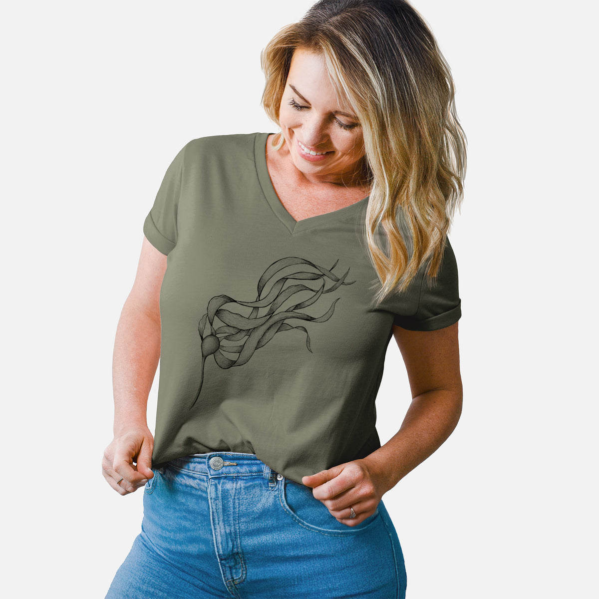 Woman wearing a military green women's relaxed fit cotton V-neck t-shirt printed with a black ink line drawing of a strand of bull kelp with long flowing blades.