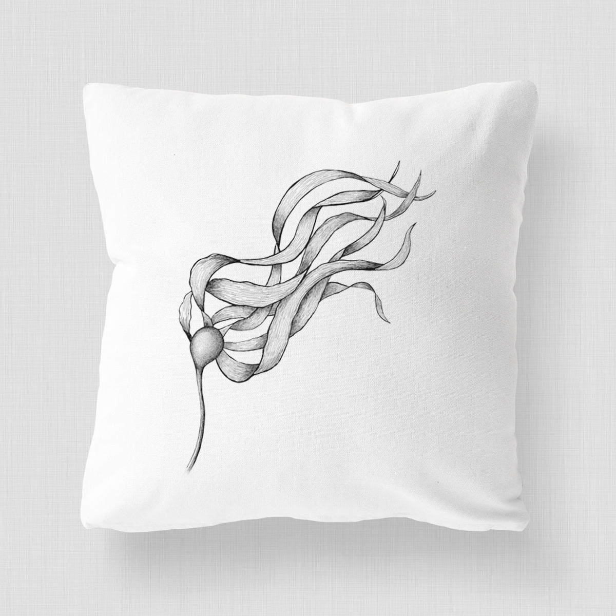 White pillow cover printed with a black ink line drawing of a strand of bull kelp with long flowing blades.