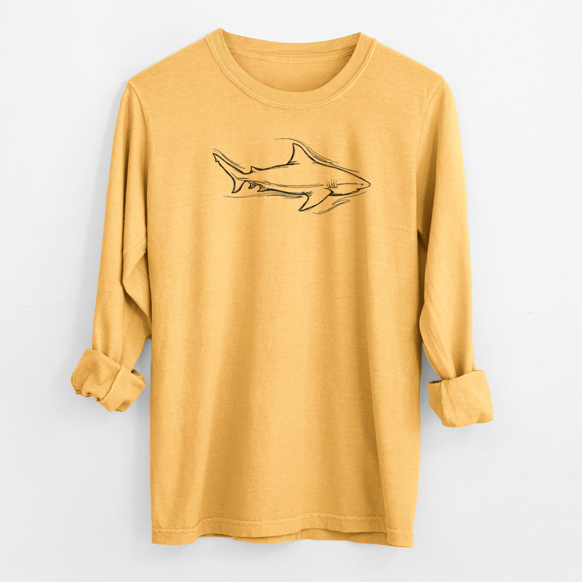 Golden wheat yellow Comfort Colors long sleeve shirt laid flat with the cuffs rolled, printed with a black ink illustration of a bull shark swimming.