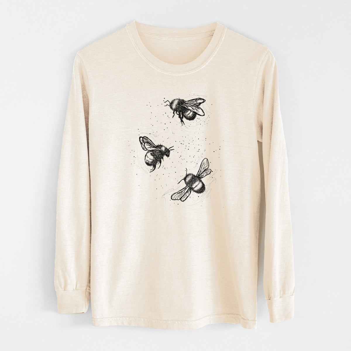 Ivory Comfort Colors long sleeve shirt laid flat, printed with a black ink illustration of three bumble bees flying.