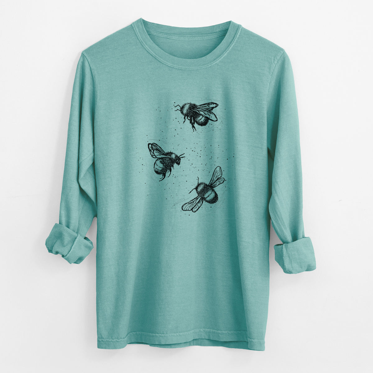 Reef green Comfort Colors long sleeve shirt laid flat with the cuffs rolled, printed with a black ink illustration of three bumble bees flying.