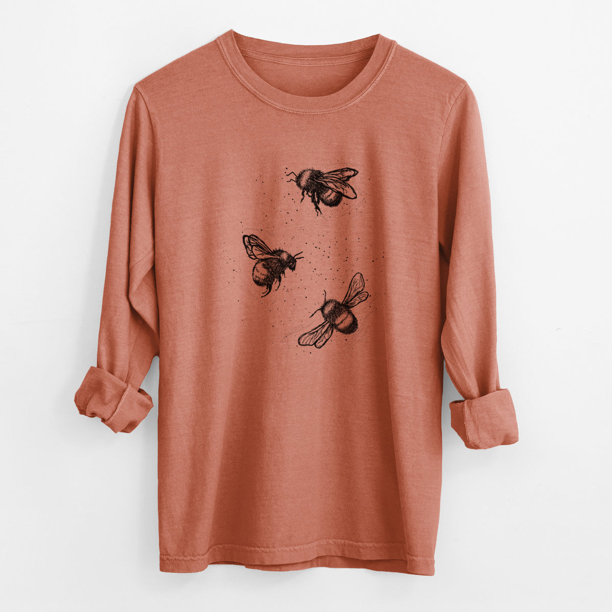 Yam burnt orange Comfort Colors long sleeve shirt laid flat with the cuffs rolled, printed with a black ink illustration of three bumble bees flying.