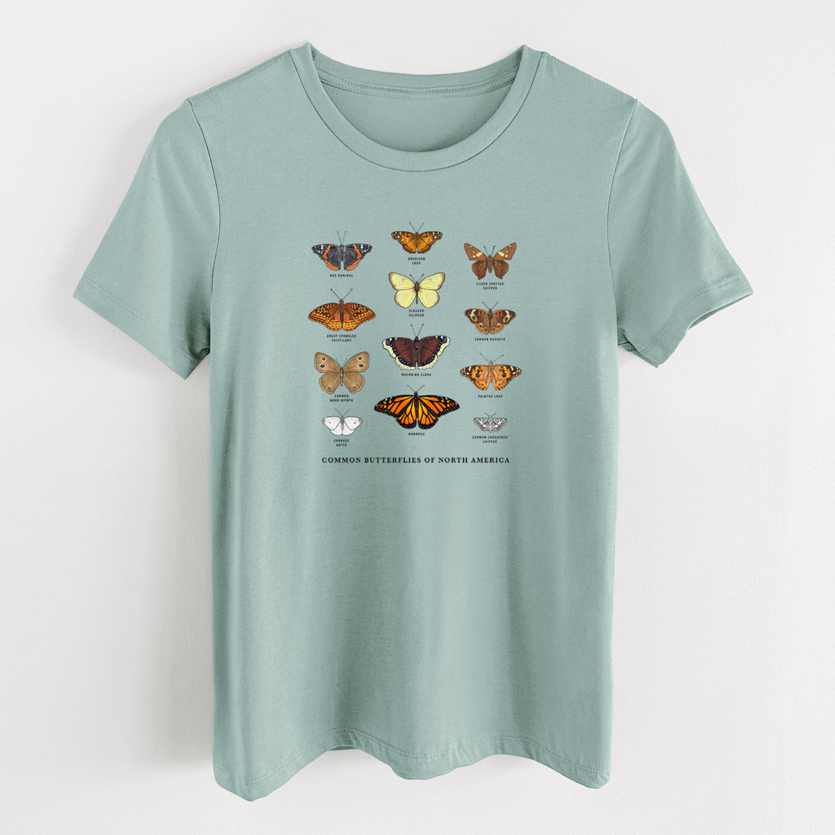 Dusty blue women's relaxed fit cotton t-shirt laid flat, printed with a full-color chart of common butterflies of North America, each labeled with its species.