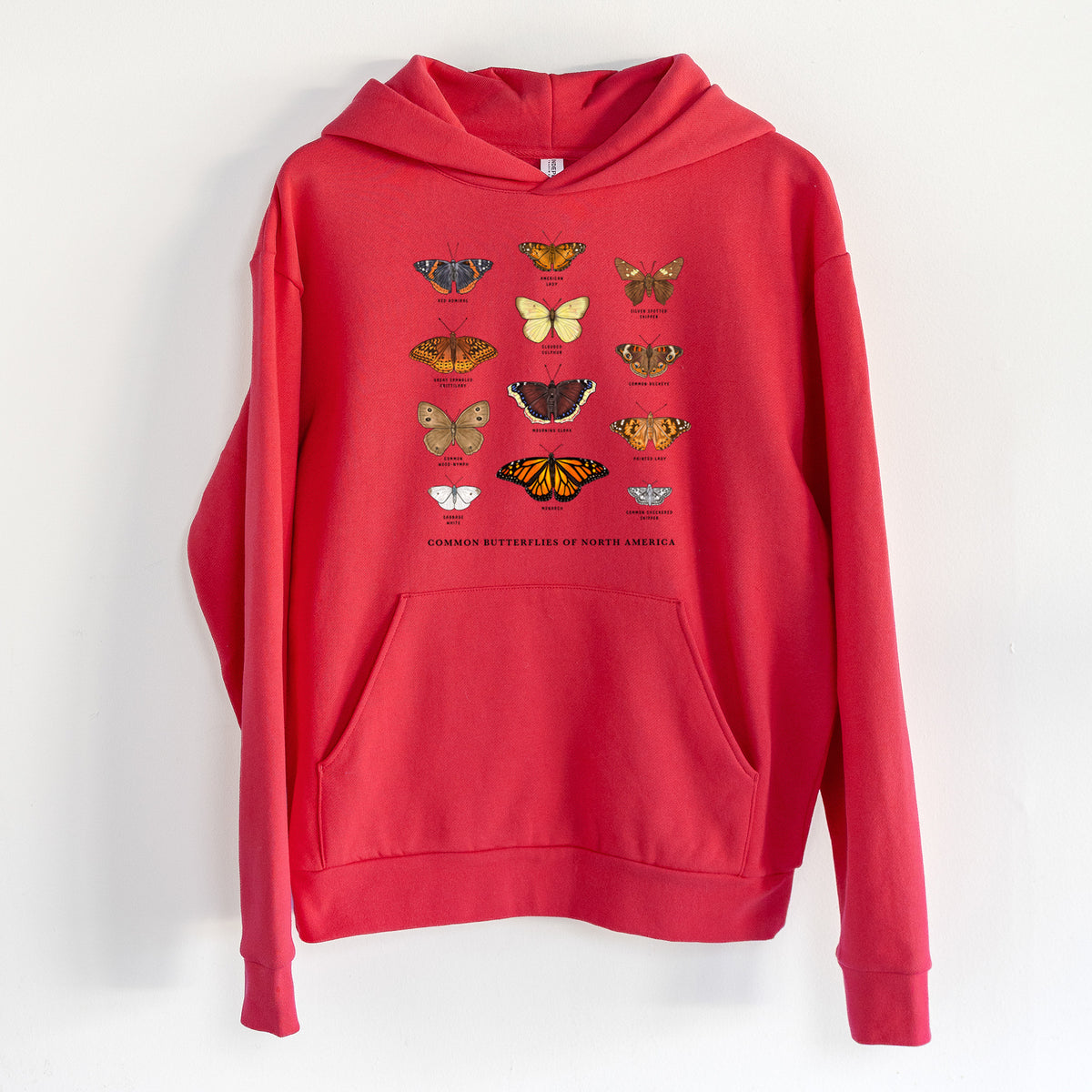 Common Butterflies of North America - Statement Midweight Hoodie in Cherry Red, hanging on a white wall, with a front kangaroo pocket and no drawcords.