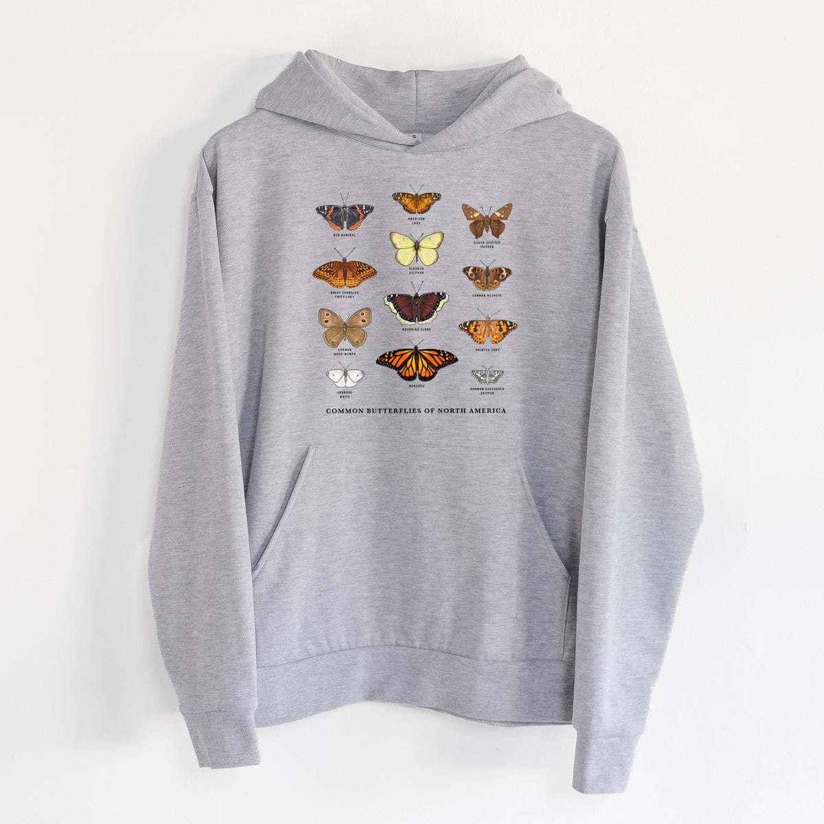 Common Butterflies of North America - Statement Midweight Hoodie in Heather Grey, hanging on a white wall, with a front kangaroo pocket and no drawcords.