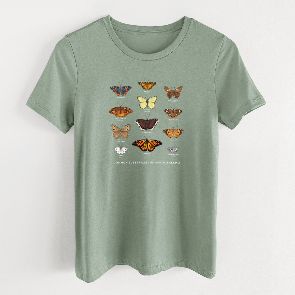 Sage green women's relaxed fit cotton t-shirt laid flat, printed with a full-color chart of common butterflies of North America, each labeled with its species.