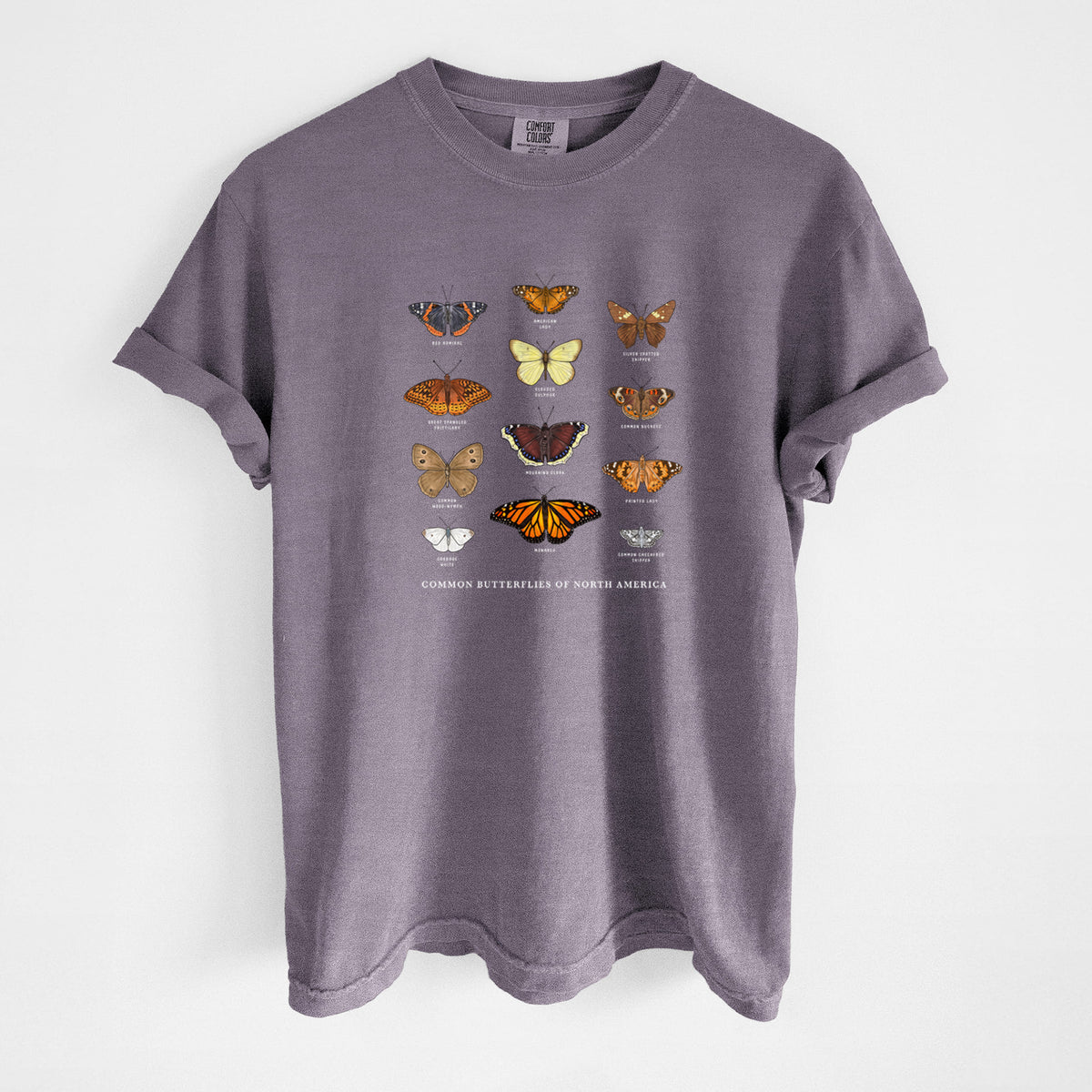 Wine red Comfort Colors t-shirt laid flat, printed with a full-color chart of common butterflies of North America, each labeled with its species.