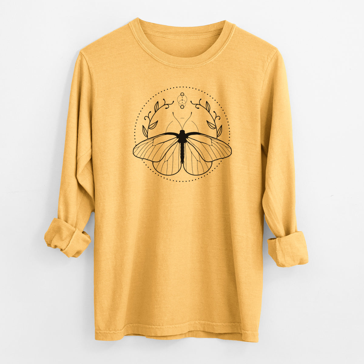 Golden wheat yellow Comfort Colors long sleeve shirt laid flat with the cuffs rolled, printed with a black ink butterfly inside a circle, framed by moon phases and leaves.