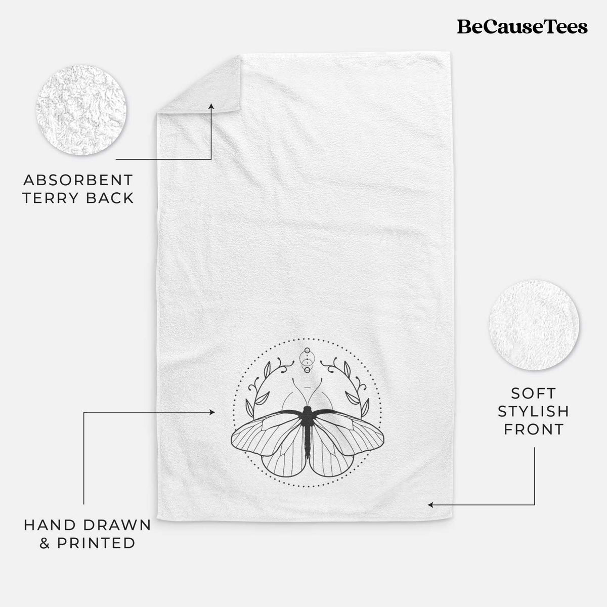 White hand towel printed with a black ink butterfly inside a circle, framed by moon phases and leaves.