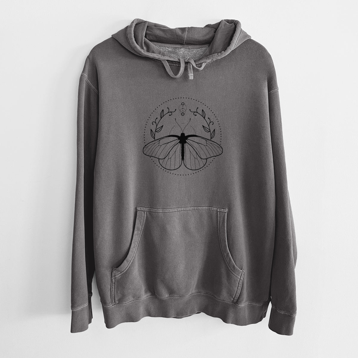 Faded black pigment dyed hoodie laid flat, printed with a black ink butterfly inside a circle, framed by moon phases and leaves.
