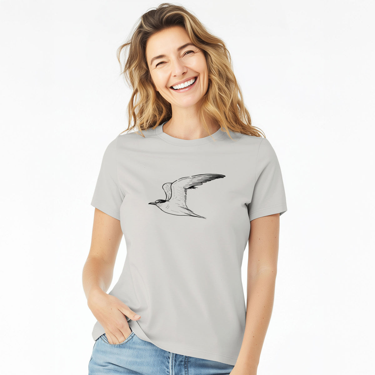 Woman wearing a lunar grey women's relaxed fit cotton t-shirt printed with a black ink illustration of a California least tern in flight.