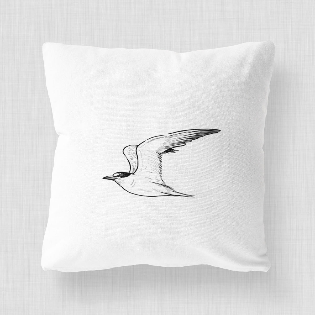 White pillow cover printed with a black ink illustration of a California least tern in flight.