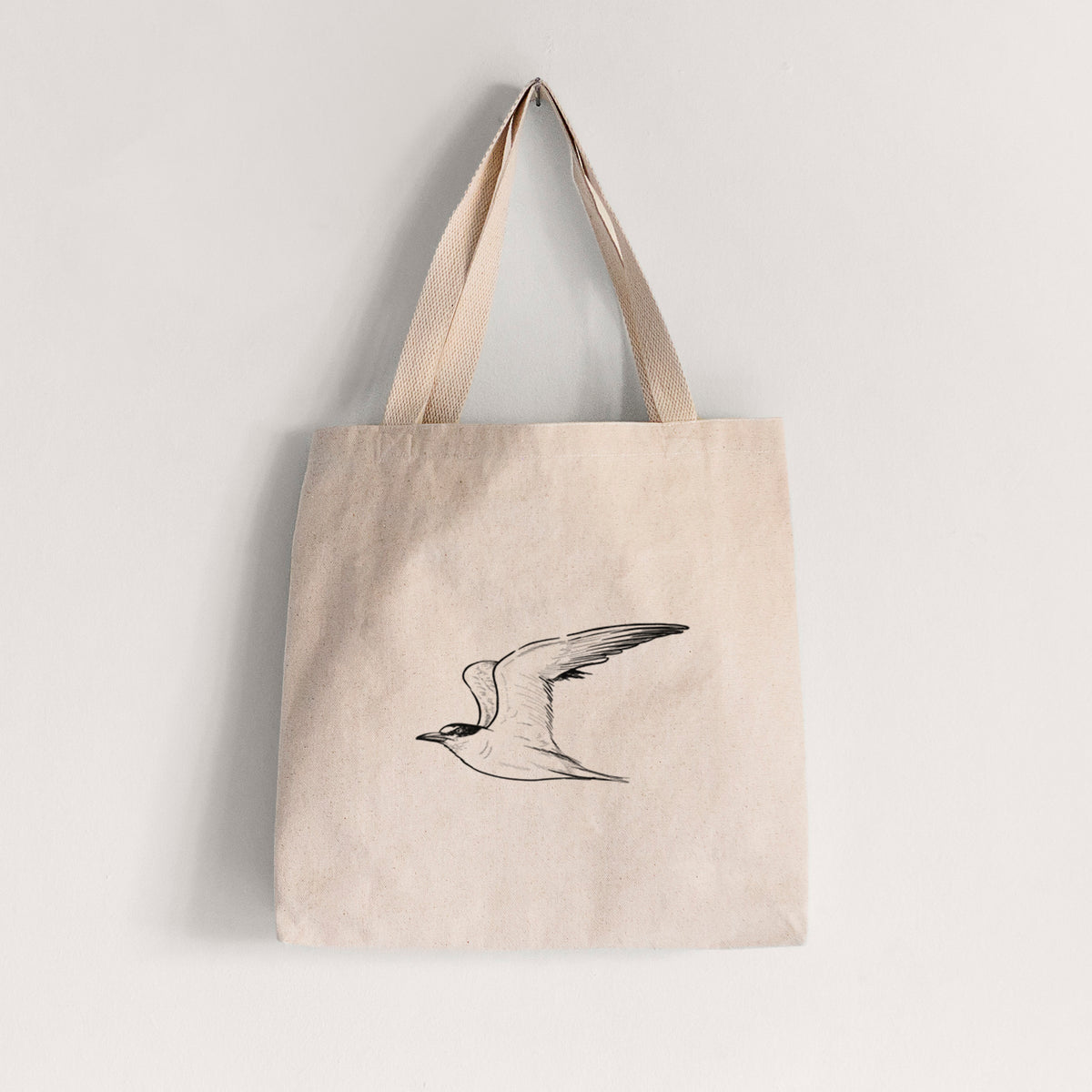 Natural canvas tote bag printed with a black ink illustration of a California least tern in flight.
