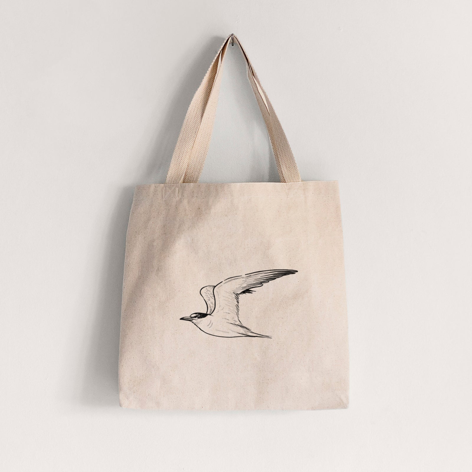 Natural canvas tote bag printed with a black ink illustration of a California least tern in flight.