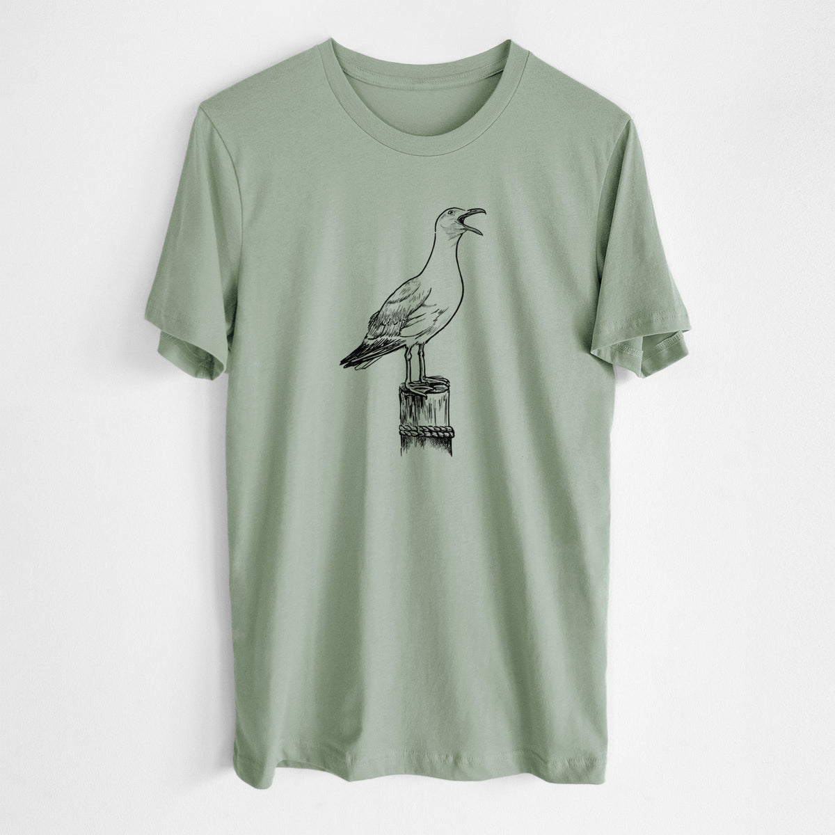 Sage green lightweight cotton t-shirt laid flat, printed with a black ink illustration of a California gull calling from a wooden post.