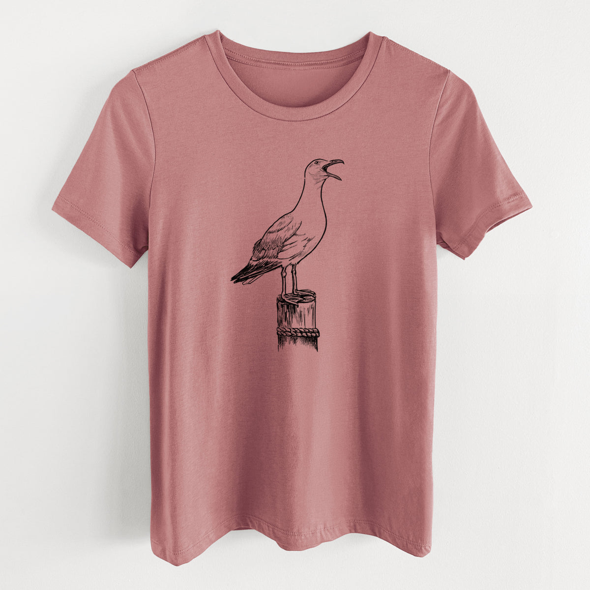 Mauve pink women's relaxed fit cotton t-shirt laid flat, printed with a black ink illustration of a California gull calling from a wooden post.