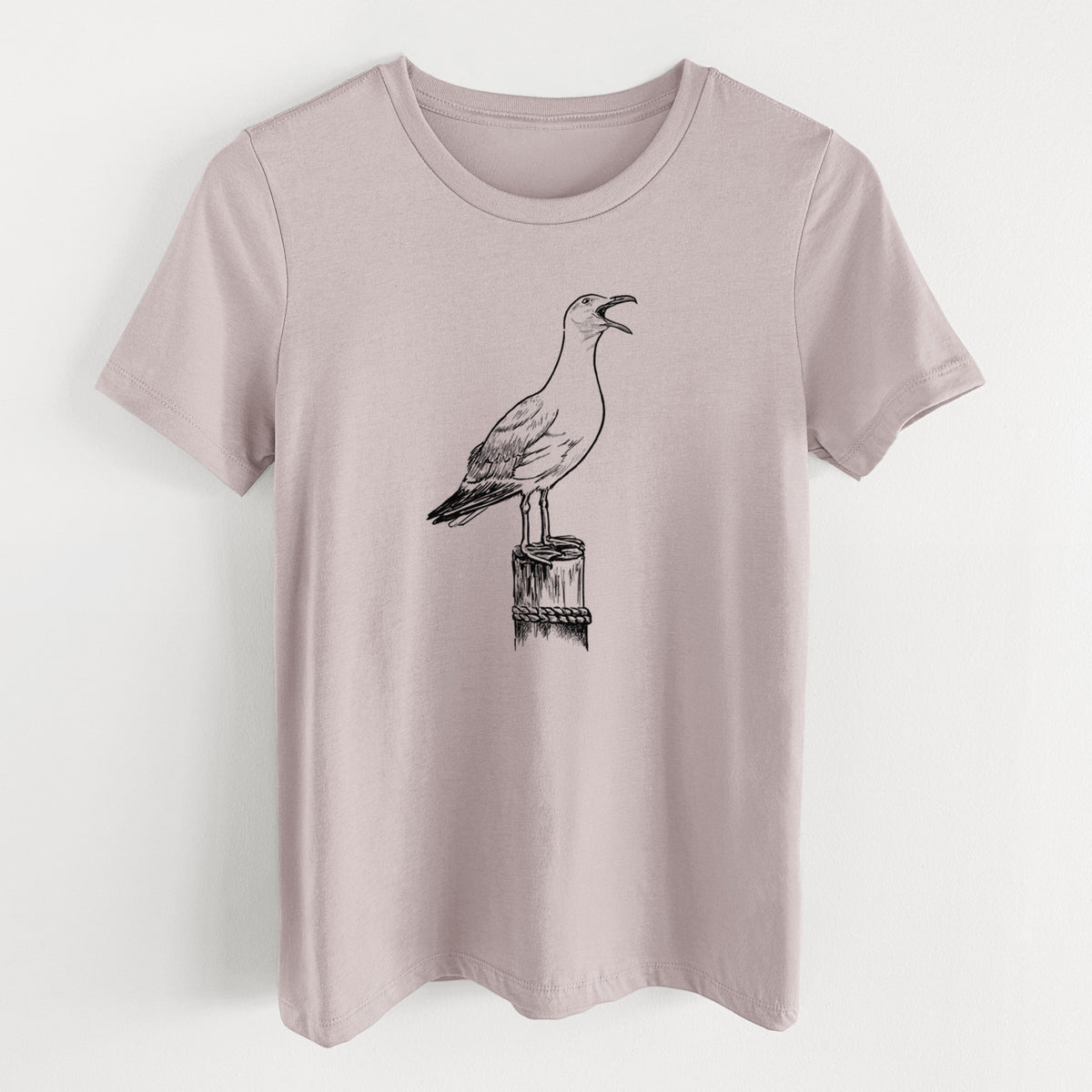 Pink gravel women's relaxed fit cotton t-shirt laid flat, printed with a black ink illustration of a California gull calling from a wooden post.