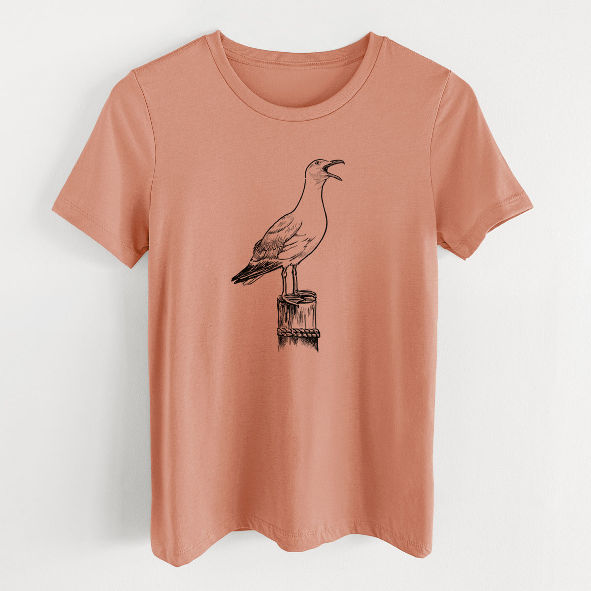 Terracotta orange women's relaxed fit cotton t-shirt laid flat, printed with a black ink illustration of a California gull calling from a wooden post.