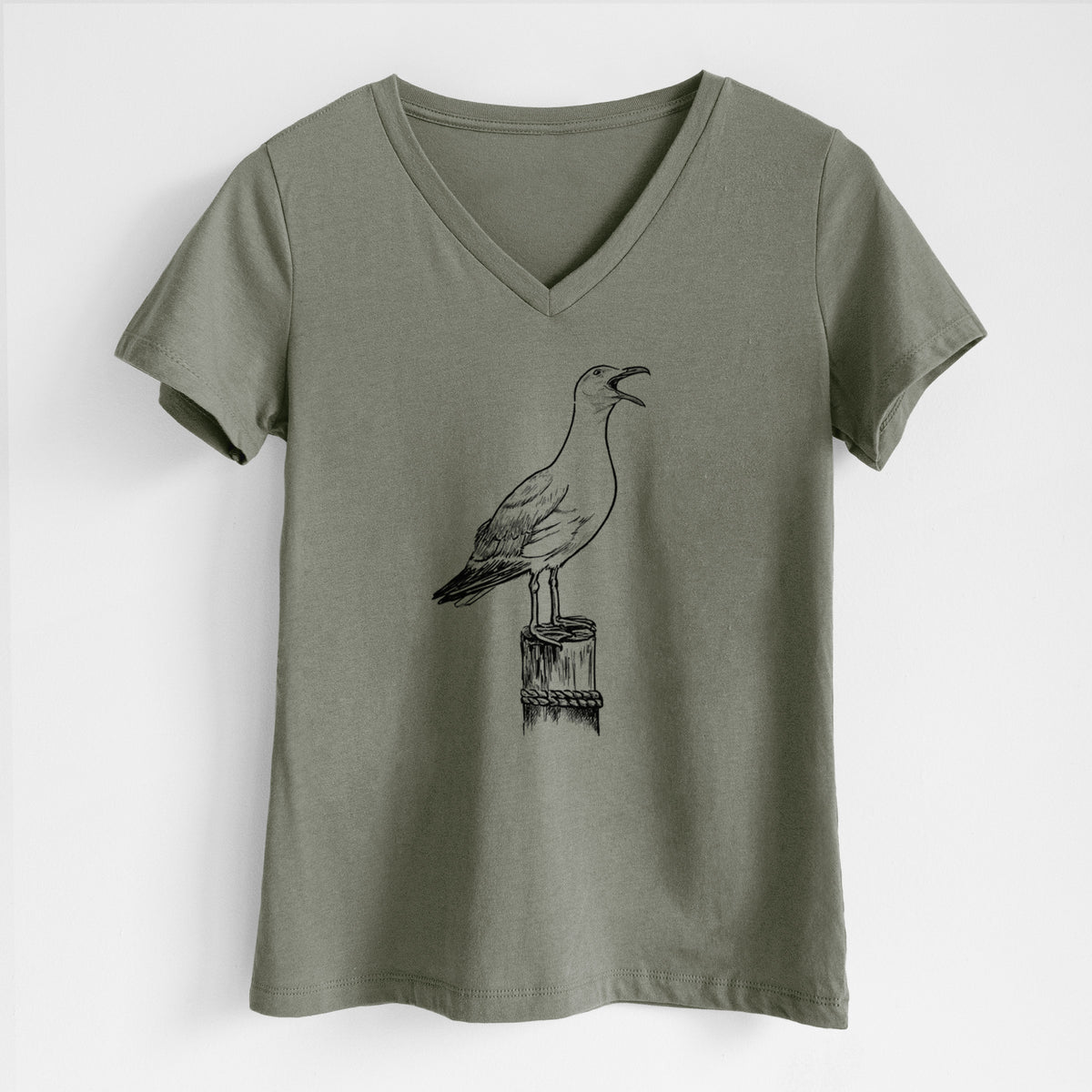 Military green women's relaxed fit cotton V-neck t-shirt laid flat, printed with a black ink illustration of a California gull calling from a wooden post.