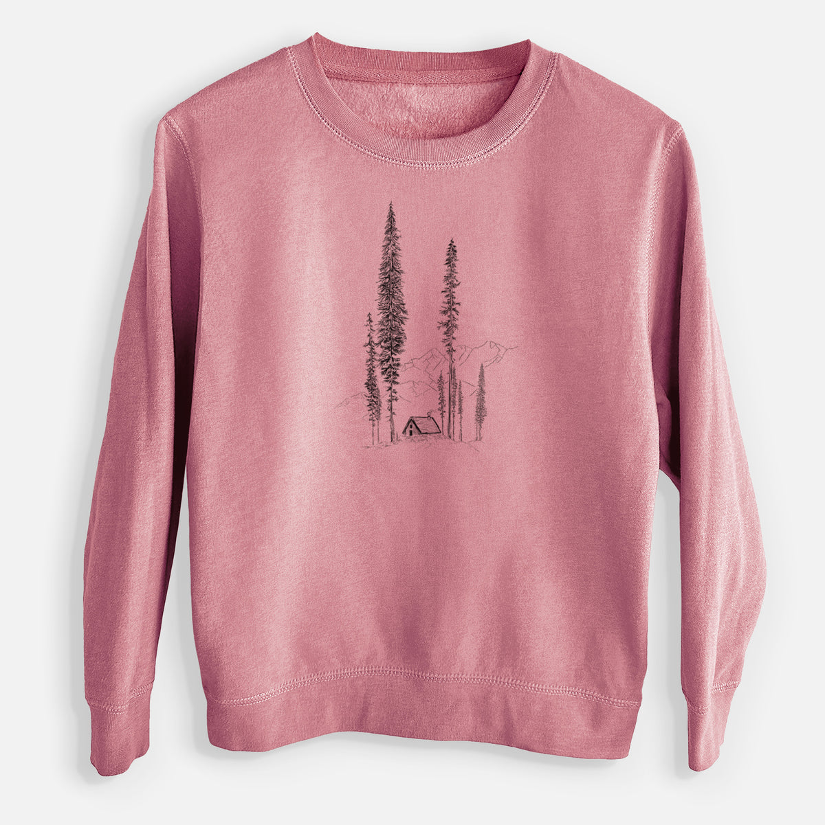 Mauve pink youth crewneck sweatshirt laid flat, printed with a black ink illustration of a small cabin nestled beneath towering pine trees.