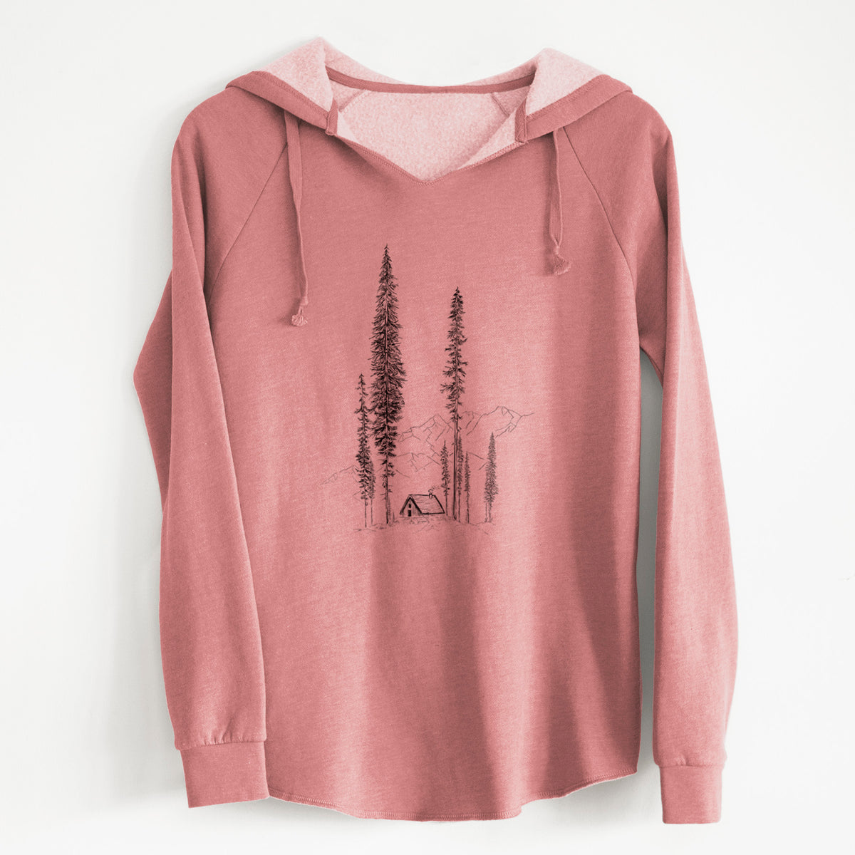 Dusty rose women's Cali Wave hooded sweatshirt laid flat, printed with a black ink illustration of a small cabin nestled beneath towering pine trees.