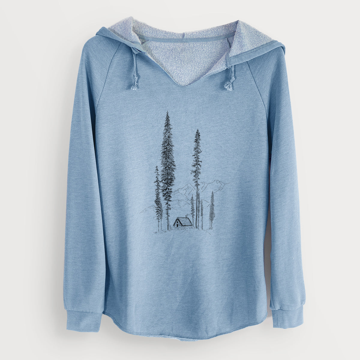 Misty blue women's Cali Wave hooded sweatshirt laid flat, printed with a black ink illustration of a small cabin nestled beneath towering pine trees.