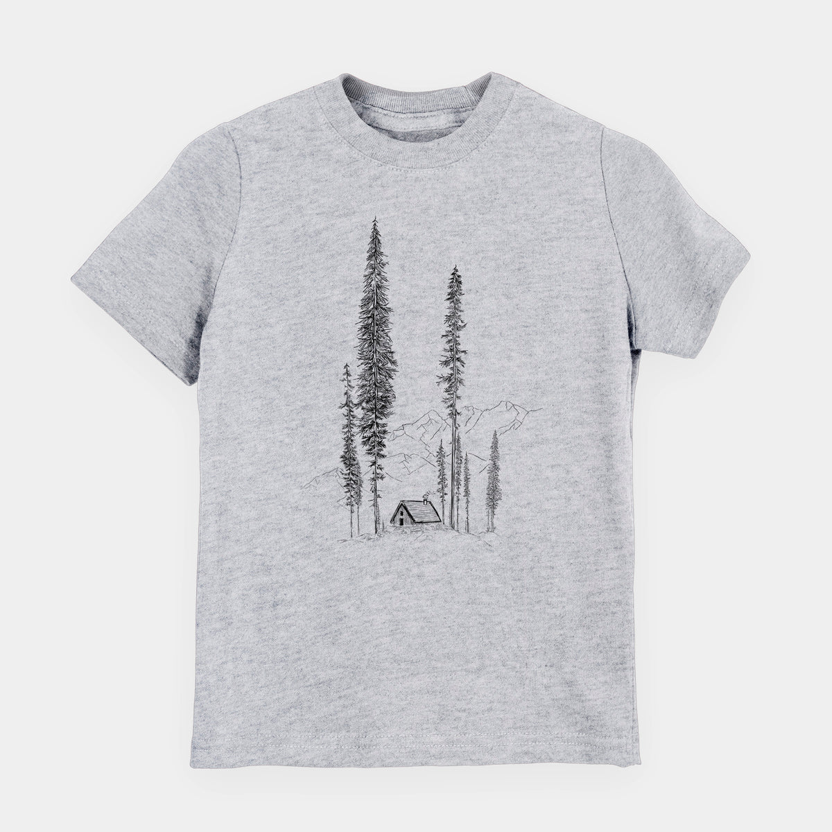 Heather grey youth t-shirt laid flat, printed with a black ink illustration of a small cabin nestled beneath towering pine trees.