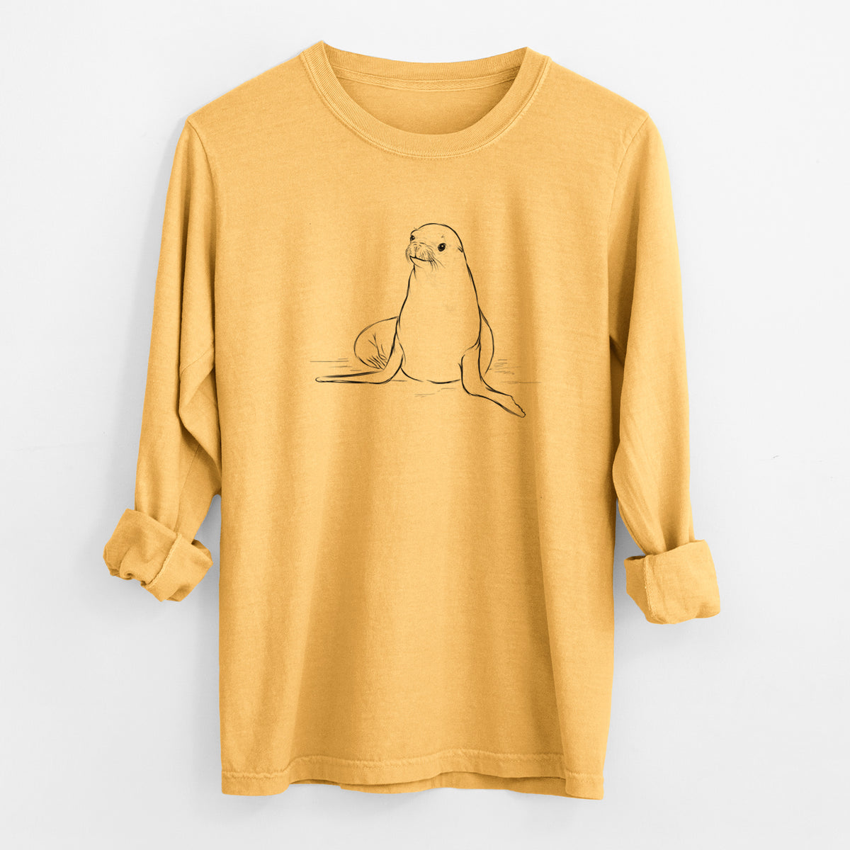 Golden wheat yellow Comfort Colors long sleeve shirt laid flat with the cuffs rolled, printed with a black ink illustration of a California sea lion sitting upright.