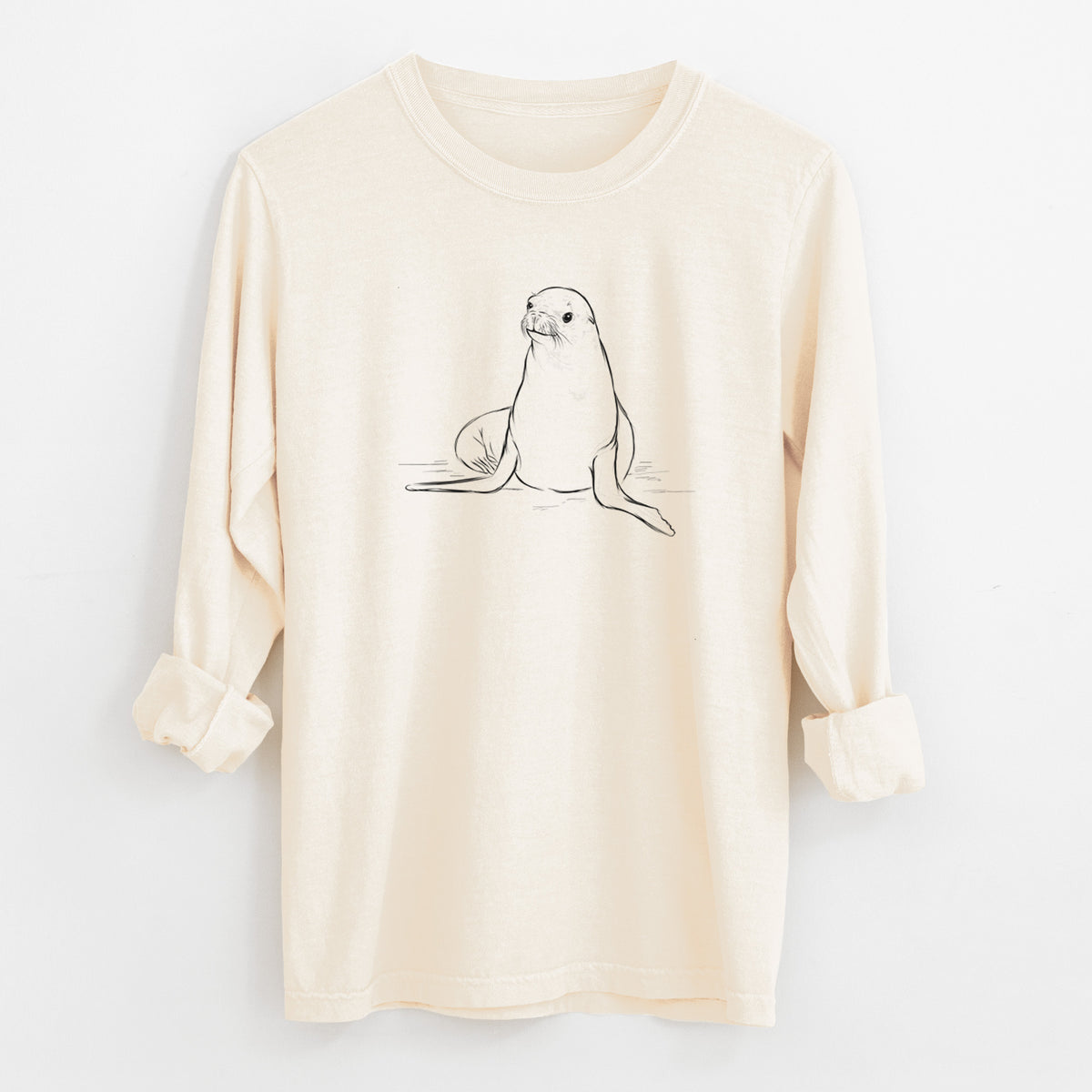 Ivory Comfort Colors long sleeve shirt laid flat with the cuffs rolled, printed with a black ink illustration of a California sea lion sitting upright.