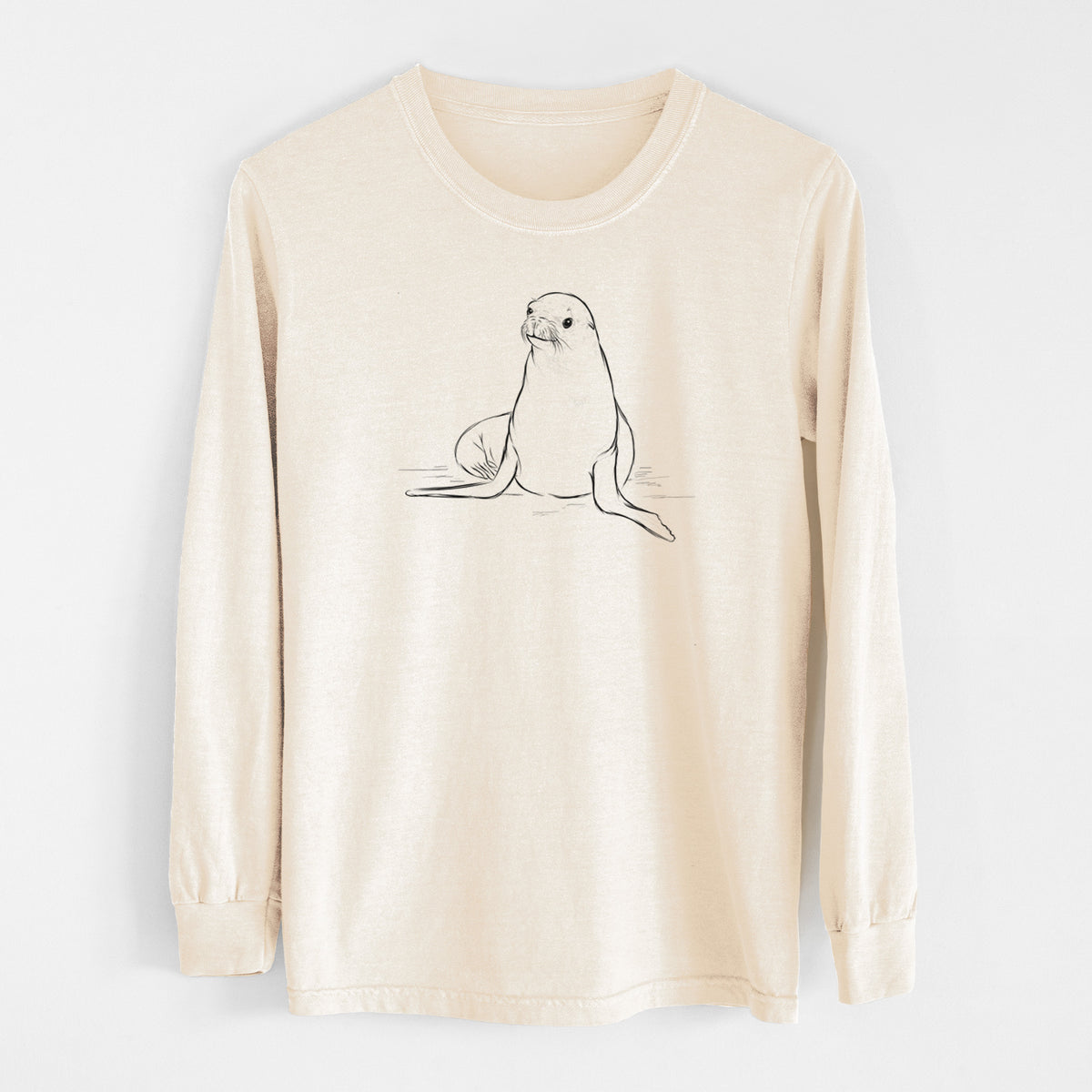 Ivory Comfort Colors long sleeve shirt laid flat, printed with a black ink illustration of a California sea lion sitting upright.