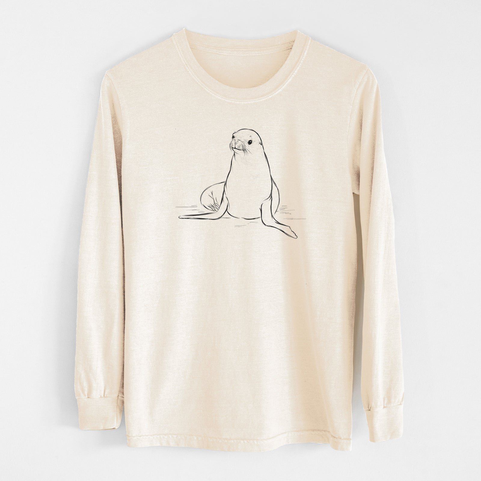 Ivory Comfort Colors long sleeve shirt laid flat, printed with a black ink illustration of a California sea lion sitting upright.