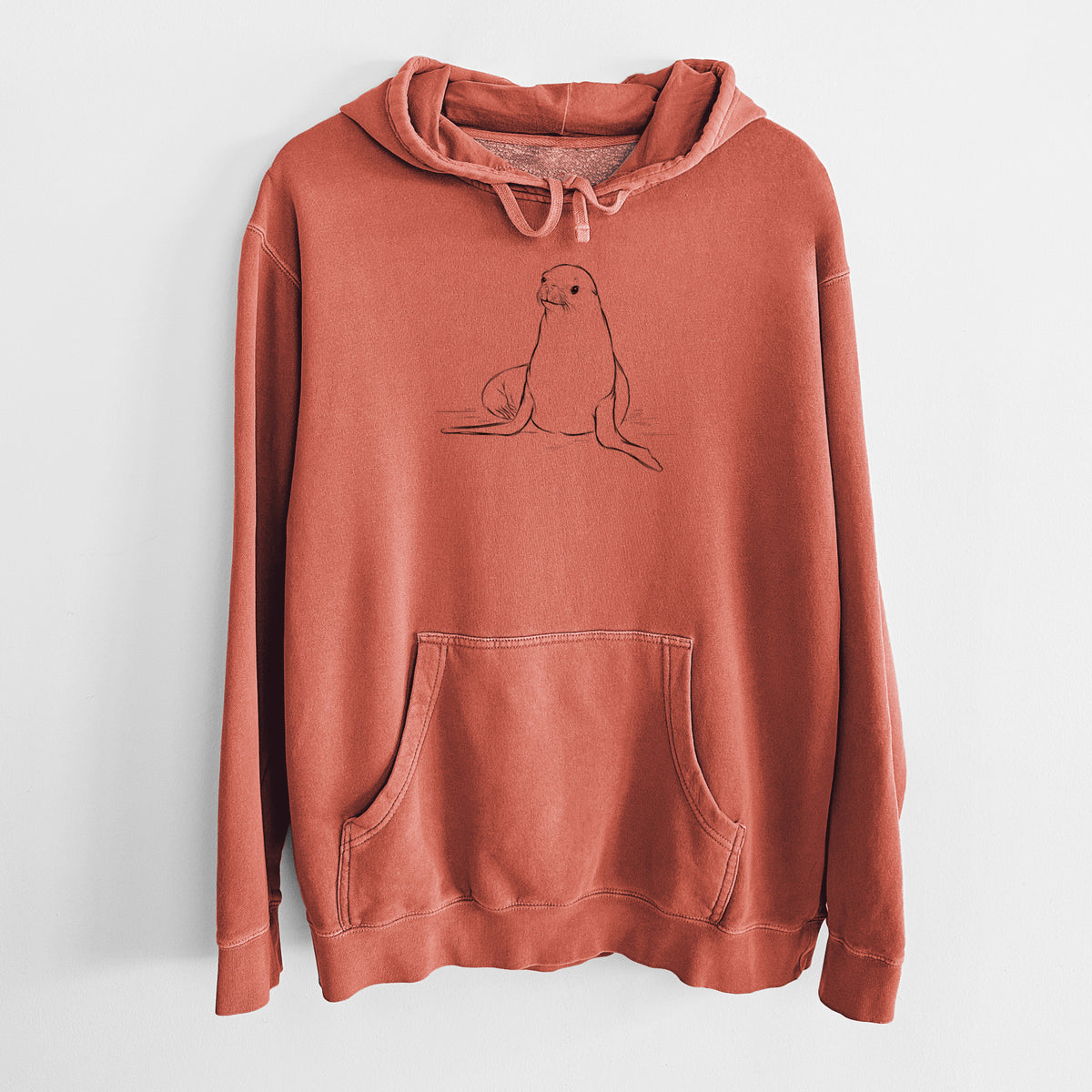 Amber orange pigment dyed hoodie laid flat, printed with a black ink illustration of a California sea lion sitting upright.