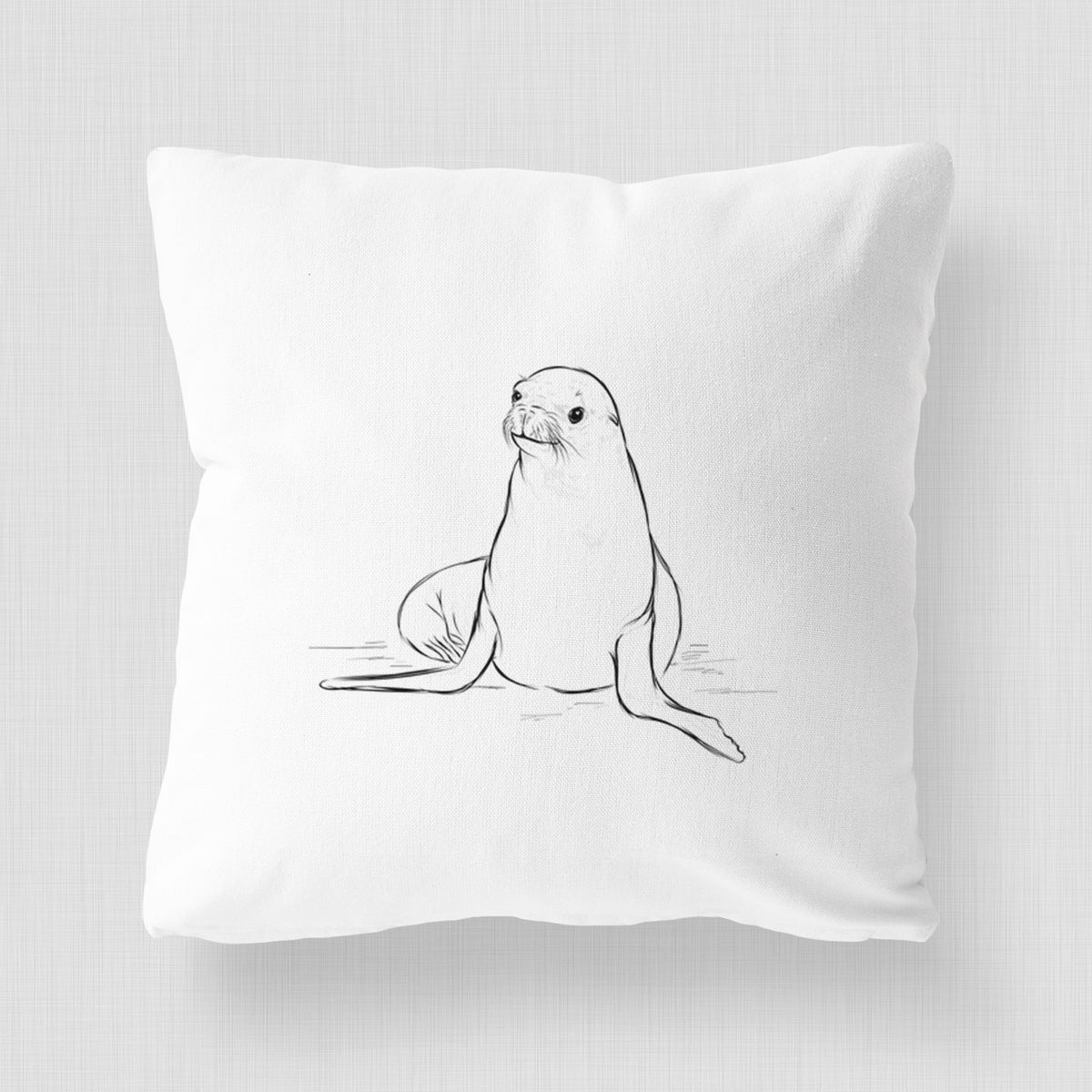 White pillow cover printed with a black ink illustration of a California sea lion sitting upright.