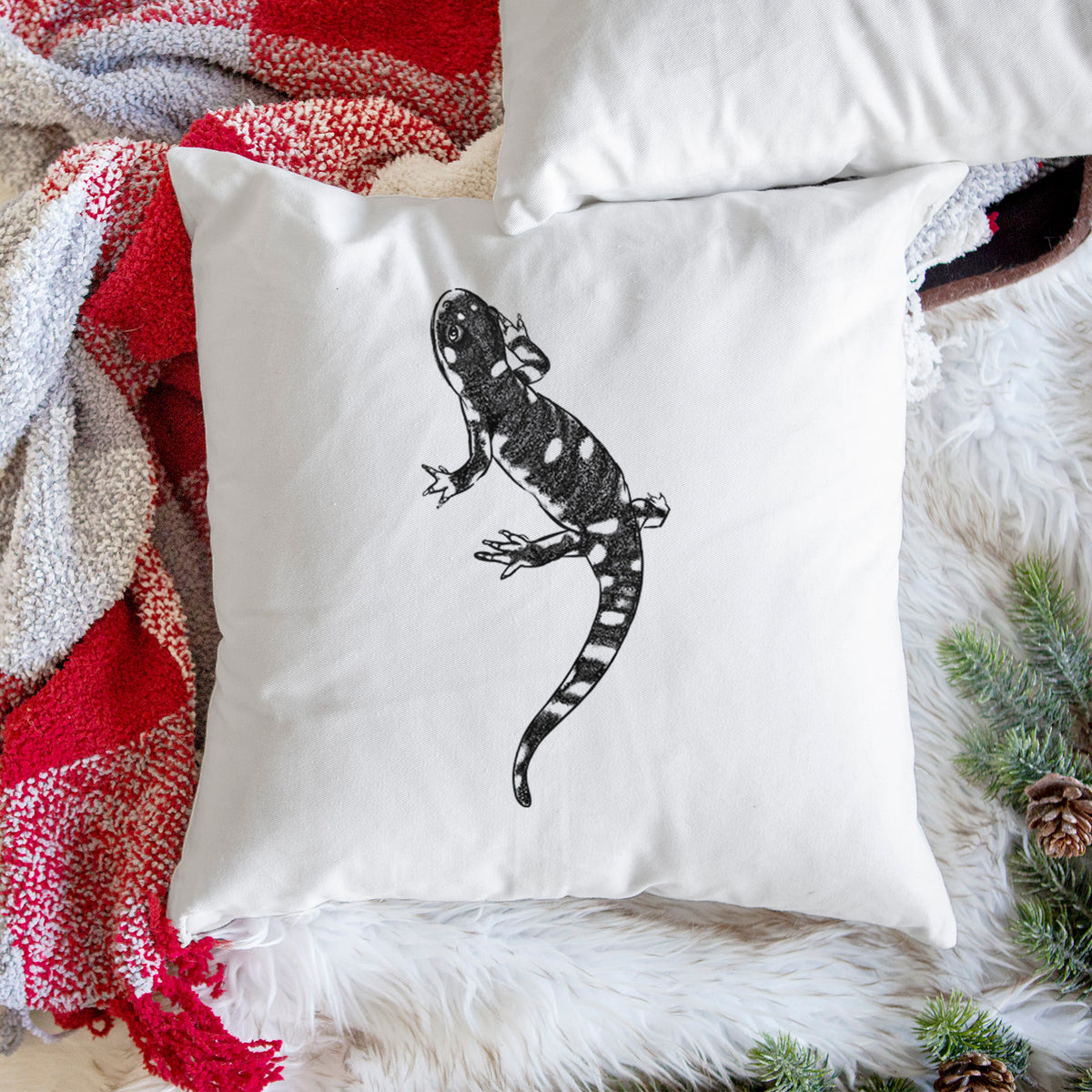 White pillow cover printed with a detailed black ink illustration of a spotted California tiger salamander, on a woven chair.