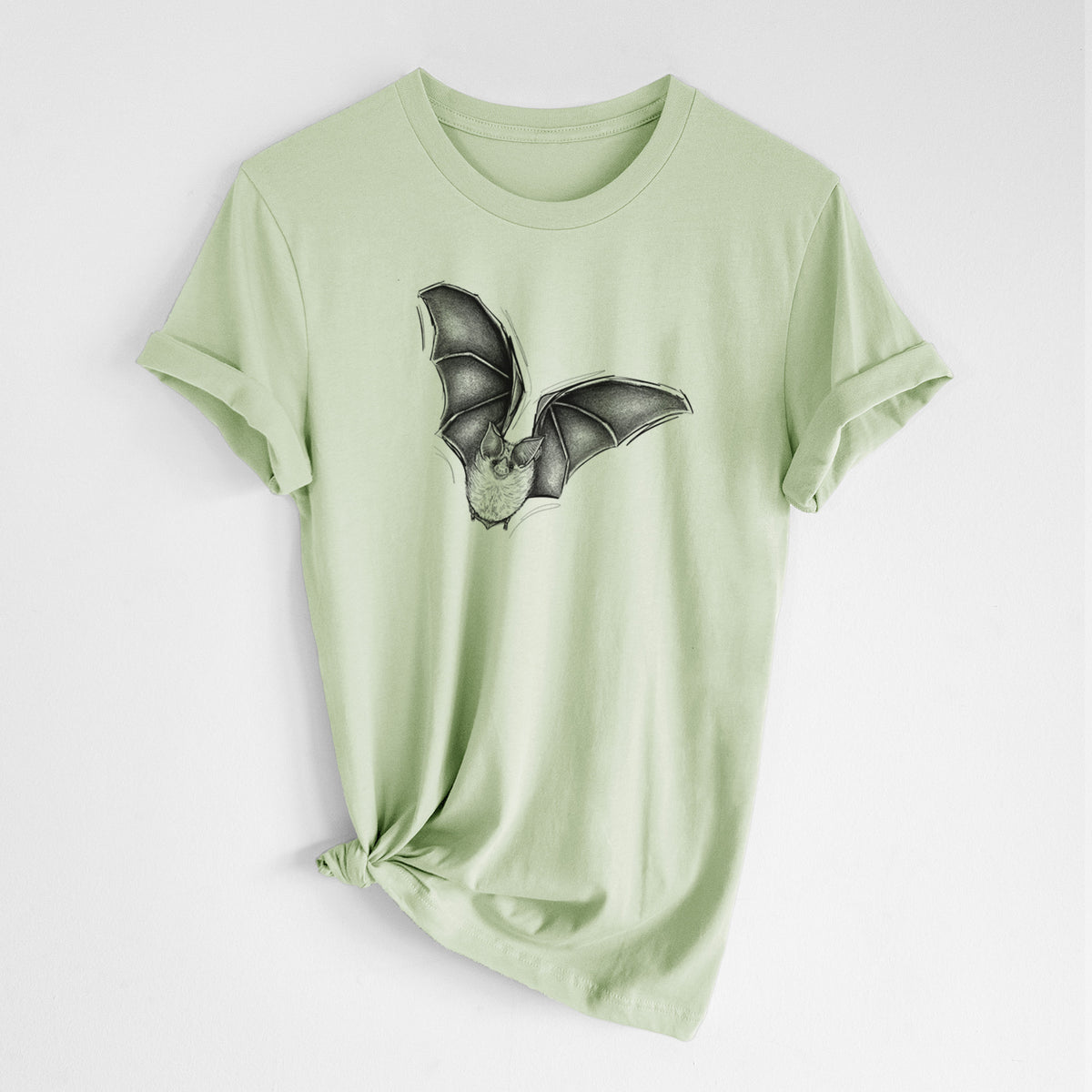 Spring green lightweight cotton t-shirt laid flat with the sleeves rolled, printed with a detailed black ink illustration of a California leaf-nosed bat in flight.