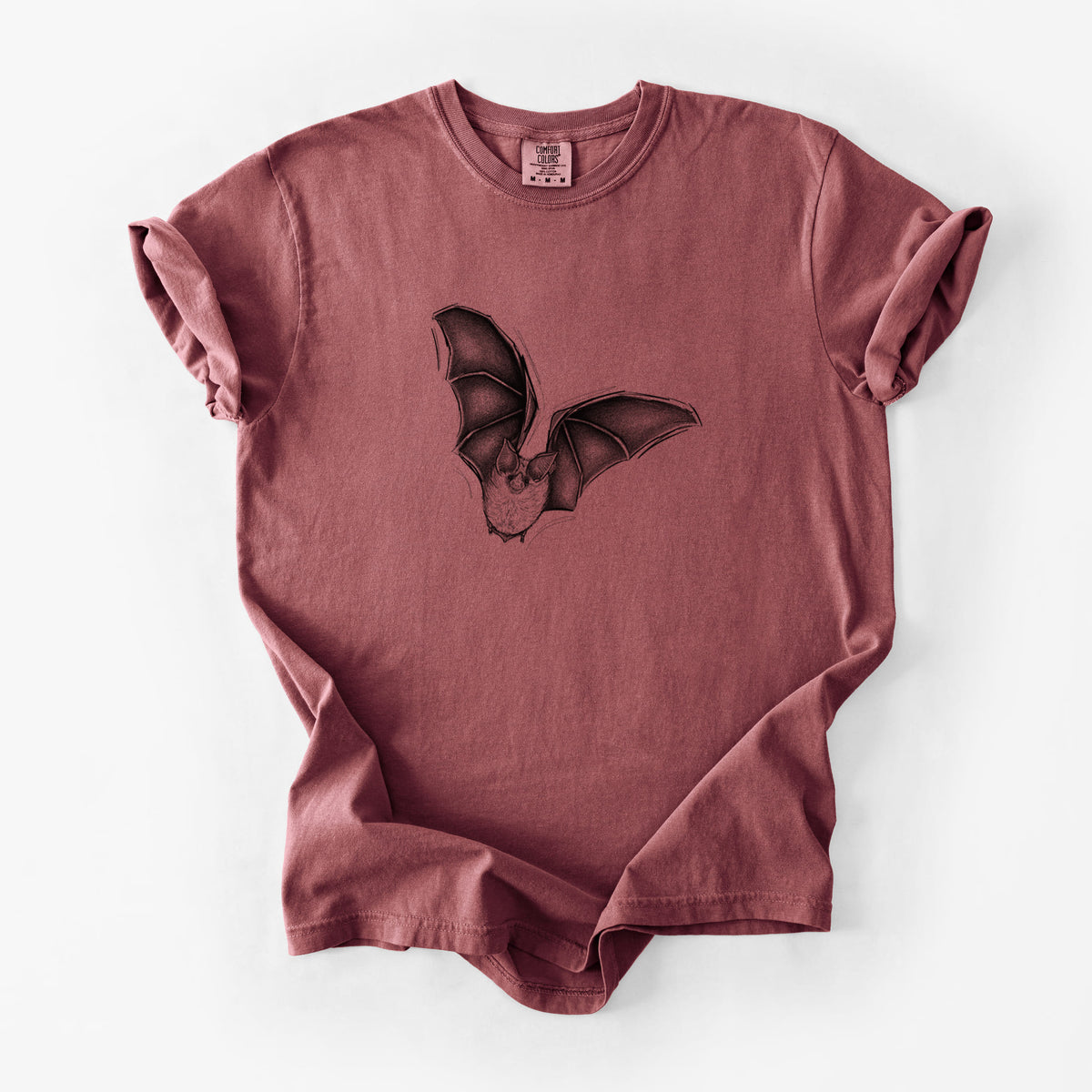 Brick red Comfort Colors t-shirt laid flat, printed with a detailed black ink illustration of a California leaf-nosed bat in flight.