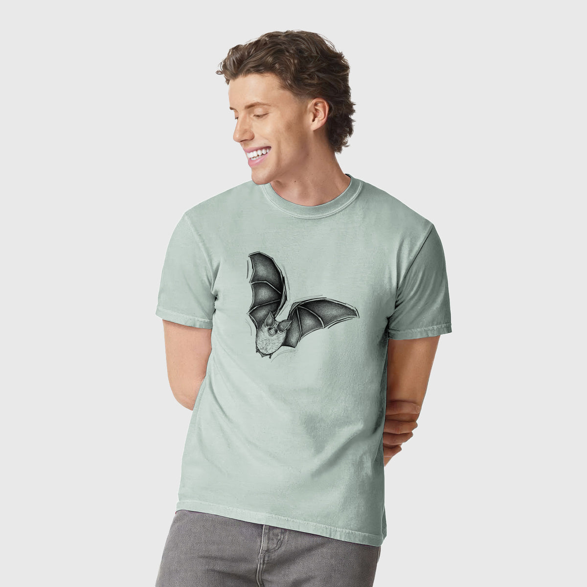Man wearing a Comfort Colors t-shirt printed with a detailed black ink illustration of a California leaf-nosed bat in flight.
